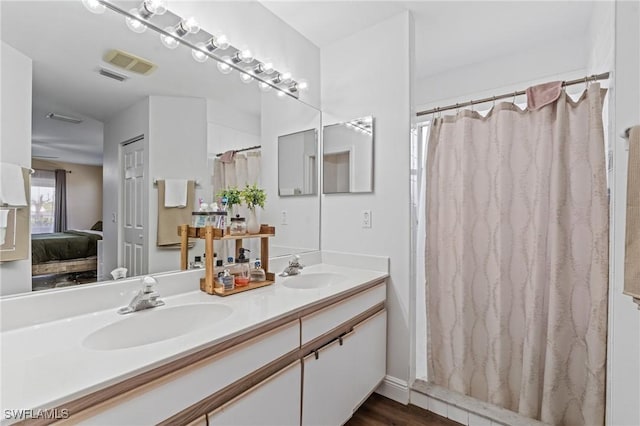 ensuite bathroom with double vanity, visible vents, a sink, and ensuite bath