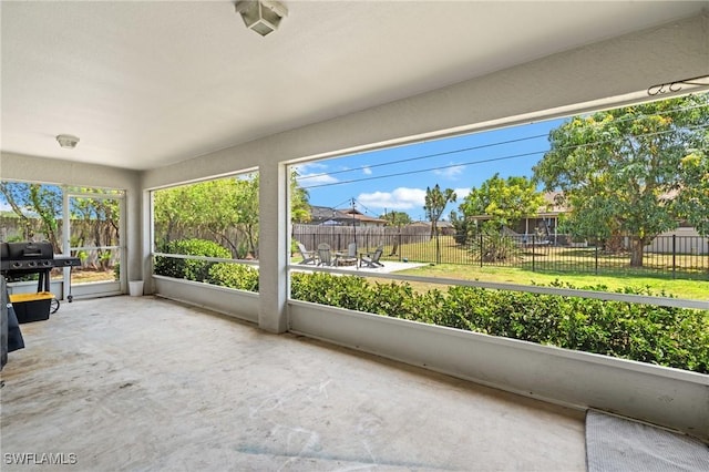 unfurnished sunroom featuring plenty of natural light and unfinished concrete flooring