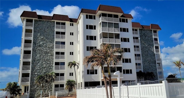 view of apartment building / complex featuring fence