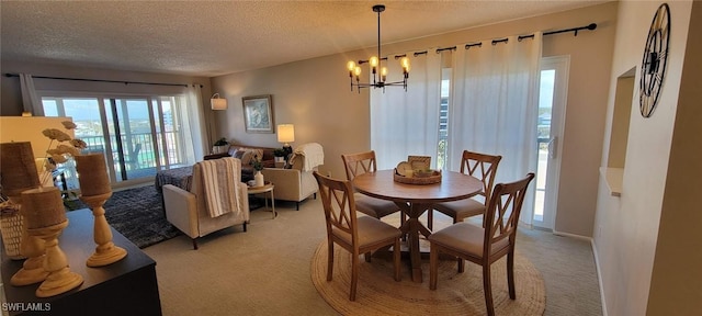 dining room featuring light carpet, a chandelier, a textured ceiling, and baseboards