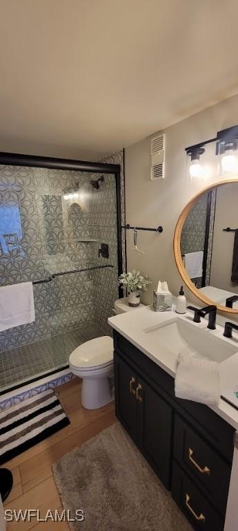 bathroom featuring vanity, a stall shower, and toilet