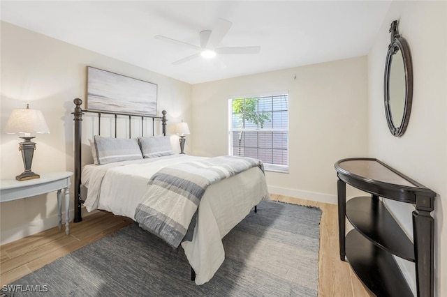 bedroom with baseboards, ceiling fan, and wood finished floors