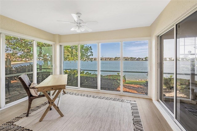sunroom / solarium with a water view, a wealth of natural light, and wood finished floors