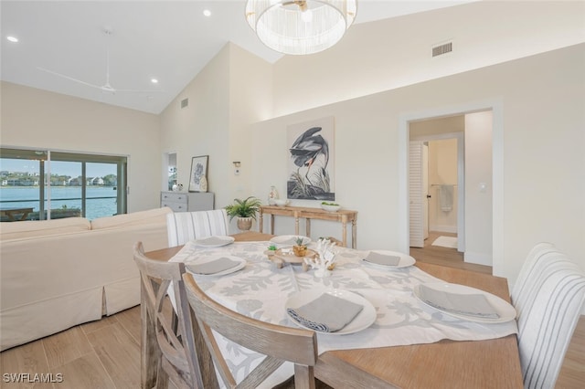 dining room with high vaulted ceiling, recessed lighting, wood finished floors, and visible vents