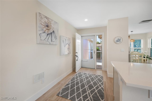 entrance foyer with recessed lighting, baseboards, visible vents, and light wood finished floors