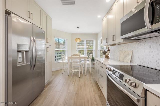 kitchen featuring decorative backsplash, visible vents, appliances with stainless steel finishes, light wood finished floors, and recessed lighting