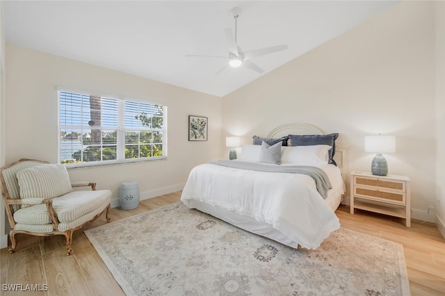 bedroom with light wood-type flooring, baseboards, ceiling fan, and vaulted ceiling