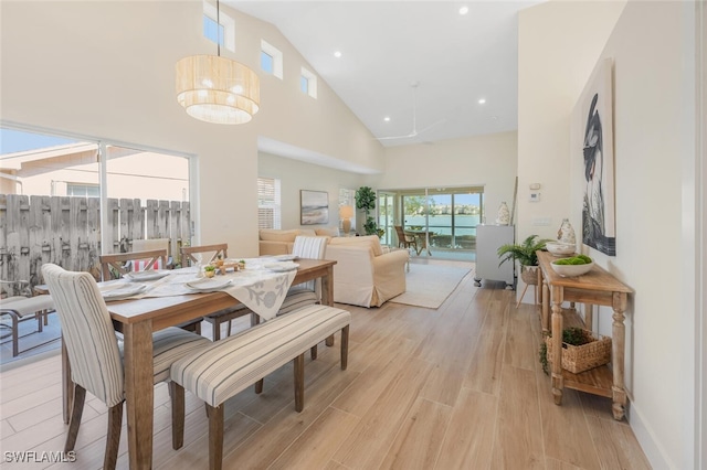 dining room featuring recessed lighting, high vaulted ceiling, and light wood-style floors