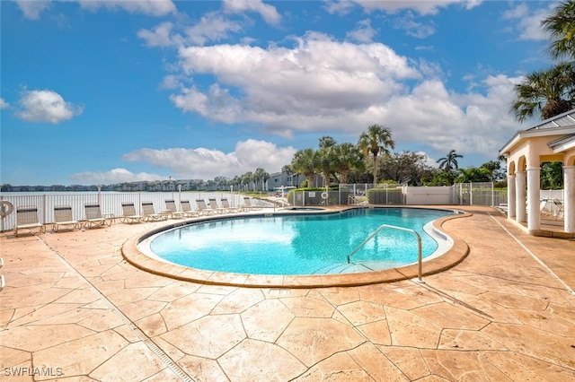 community pool with fence and a patio