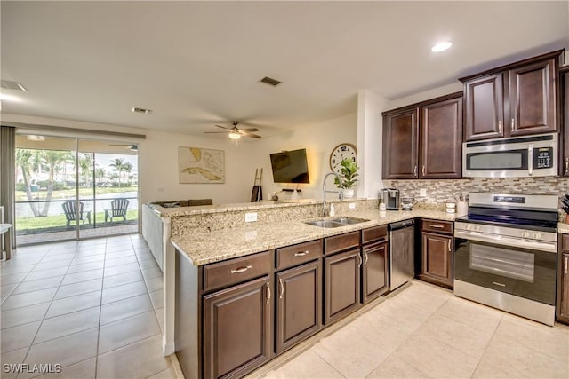 kitchen featuring a ceiling fan, a sink, light tile patterned floors, a peninsula, and stainless steel appliances