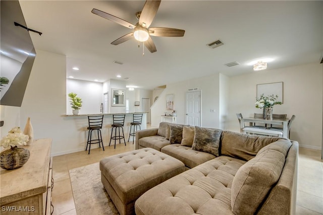 living room featuring visible vents, baseboards, ceiling fan, and light tile patterned floors