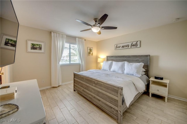 bedroom with a ceiling fan, baseboards, and light wood-style floors