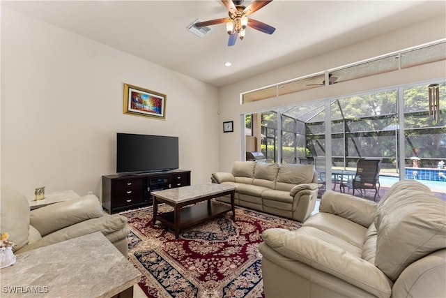 living room featuring a healthy amount of sunlight, a ceiling fan, visible vents, and a sunroom