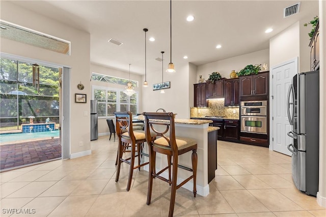 kitchen with visible vents, light tile patterned floors, backsplash, and appliances with stainless steel finishes