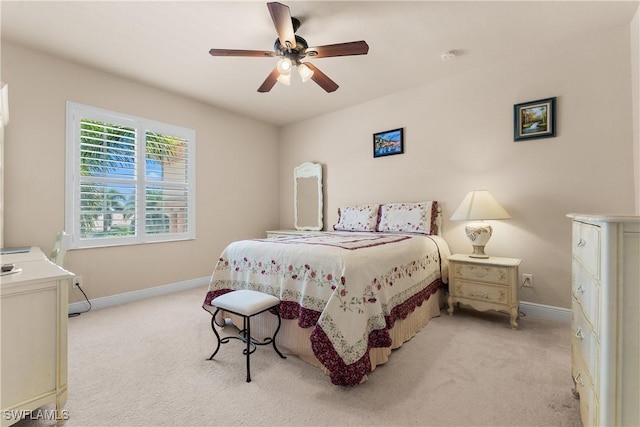 bedroom featuring a ceiling fan, light carpet, and baseboards