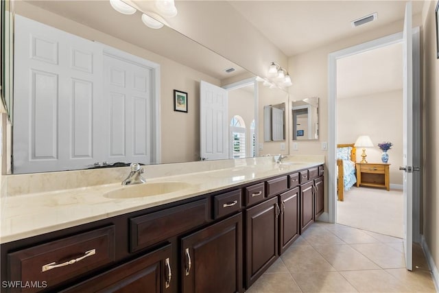 bathroom with tile patterned floors, visible vents, double vanity, and a sink