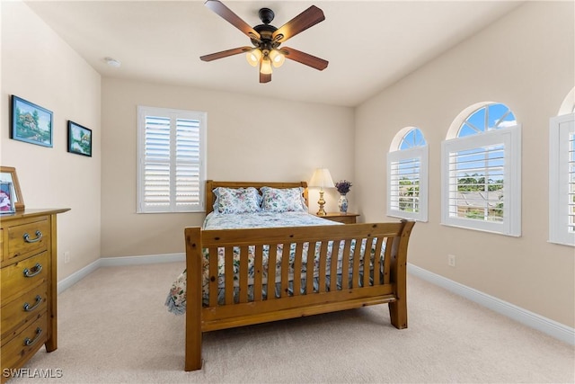 bedroom with baseboards, light carpet, and multiple windows