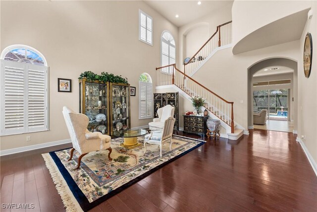 interior space featuring hardwood / wood-style floors, stairs, a healthy amount of sunlight, and a high ceiling