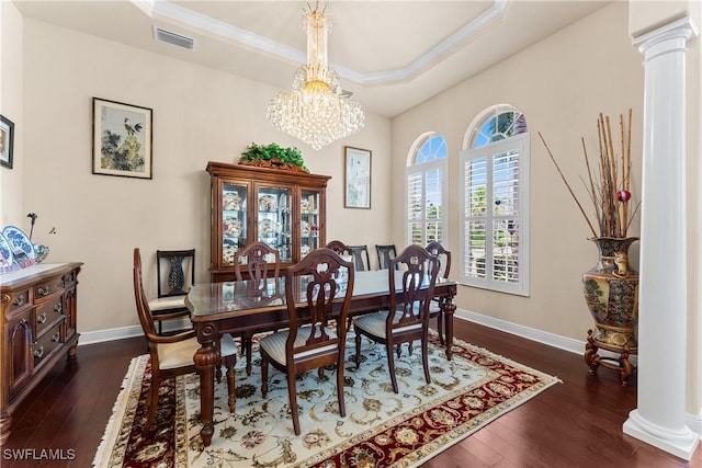 dining area featuring ornate columns, dark wood-style flooring, visible vents, crown molding, and a tray ceiling