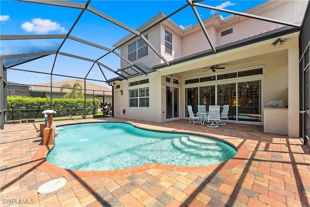 pool featuring a patio, a ceiling fan, exterior kitchen, and a lanai