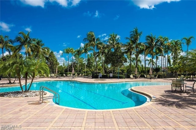 community pool featuring a patio and fence