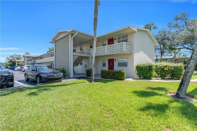 1015 Tropic Ter, North Fort Myers, FL 33903 - exterior space with stucco siding, a yard, uncovered parking, and a balcony