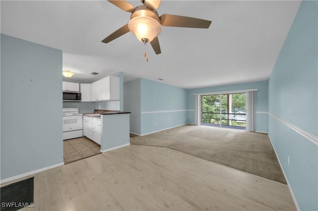 1015 Tropic Ter, North Fort Myers, FL 33903 - unfurnished living room featuring baseboards, ceiling fan, and light wood-style floors