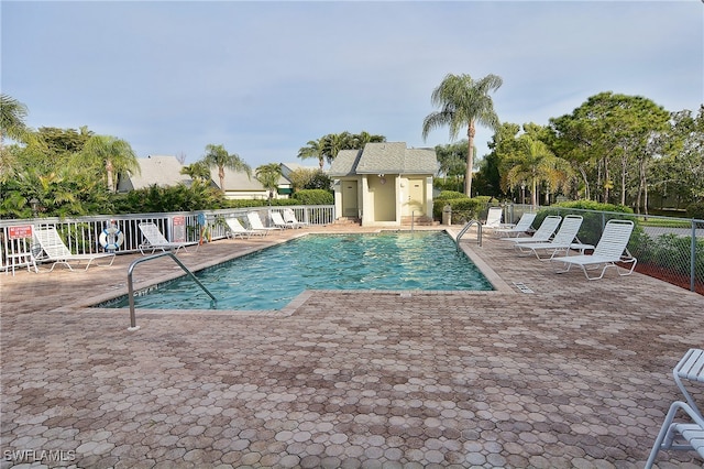 community pool featuring fence and a patio