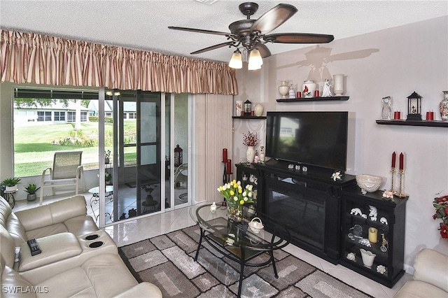 living area with a ceiling fan and a textured ceiling
