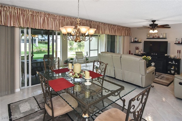 tiled dining area featuring ceiling fan with notable chandelier and a textured ceiling