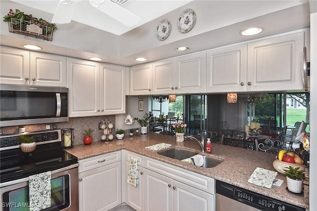 kitchen with recessed lighting, a sink, white cabinets, and stainless steel appliances