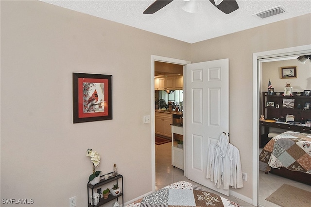 bedroom featuring visible vents, a ceiling fan, and light tile patterned flooring