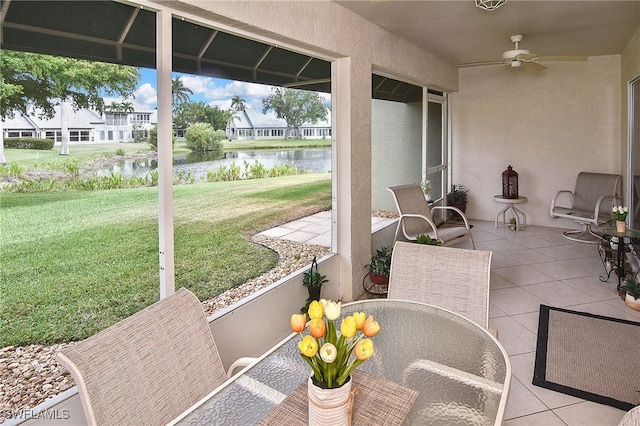 view of patio / terrace with outdoor dining area, a water view, and ceiling fan