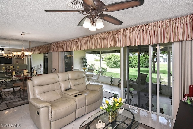 living area featuring light tile patterned floors, ceiling fan with notable chandelier, a textured ceiling, and visible vents