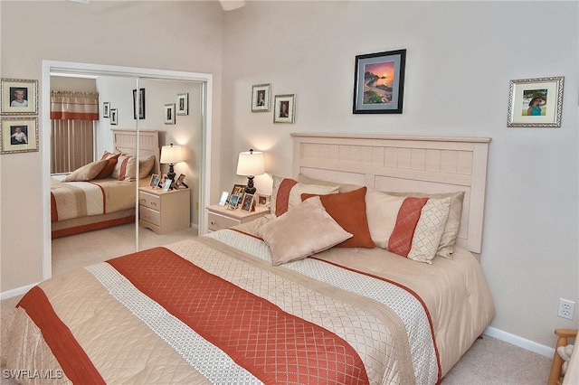 carpeted bedroom with baseboards and a closet