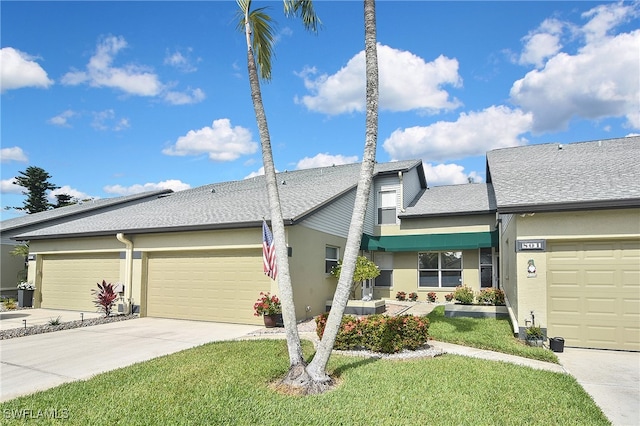 view of front facade featuring roof with shingles, an attached garage, a front lawn, stucco siding, and driveway