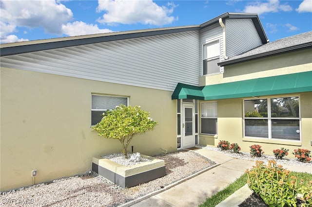 doorway to property featuring stucco siding