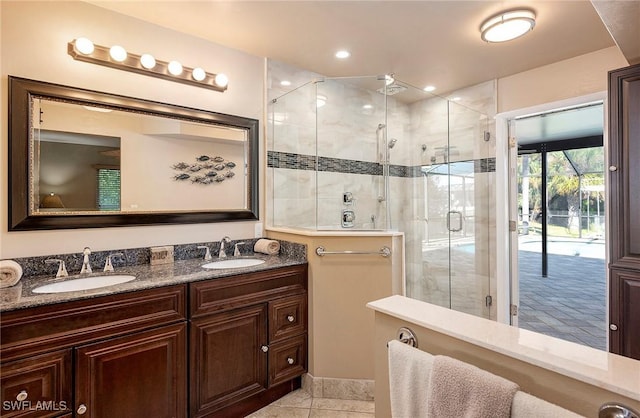 bathroom featuring double vanity, a sink, and a shower stall