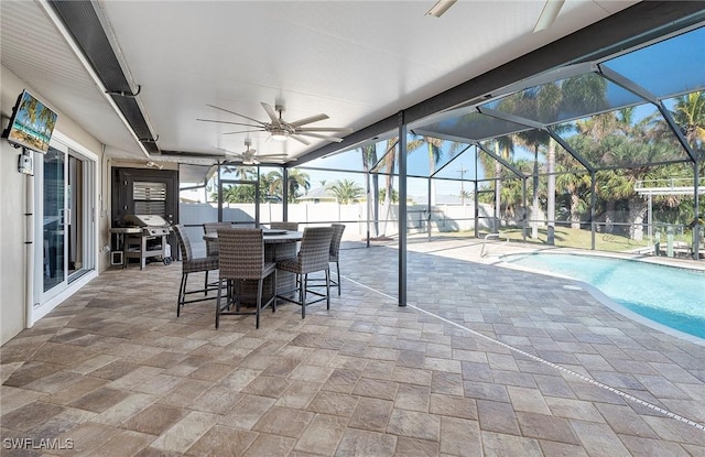 exterior space featuring a lanai, ceiling fan, a patio, and a fenced in pool