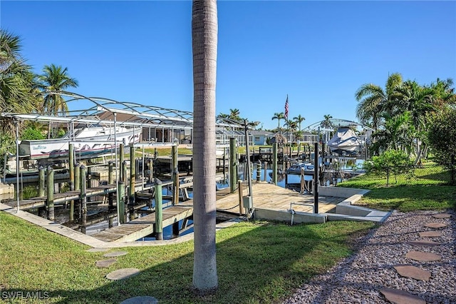 view of dock featuring a lawn, a water view, and boat lift