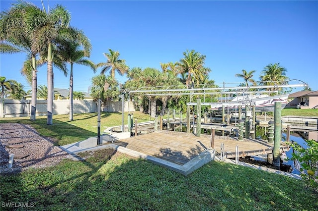 exterior space featuring a lawn, fence, and boat lift