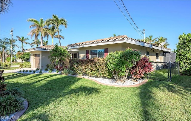 exterior space featuring a front lawn, fence, stucco siding, and a tiled roof