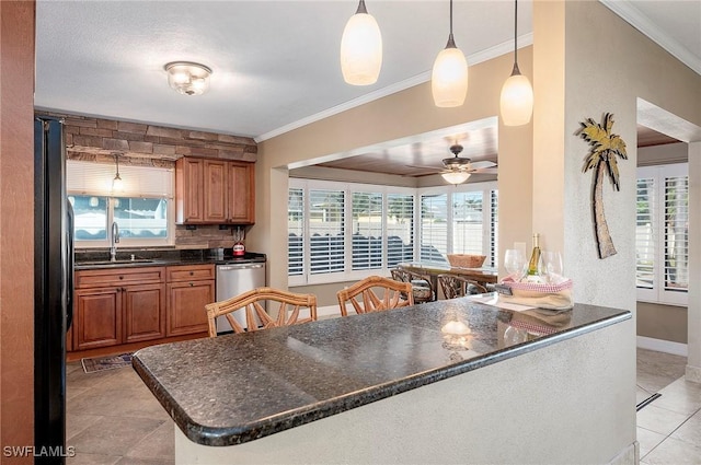 kitchen with stainless steel dishwasher, crown molding, a sink, light tile patterned flooring, and a wealth of natural light