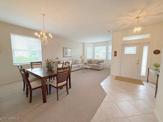 7539 Berkshire Pines Dr, Naples, FL 34104 - dining area featuring a chandelier, light tile patterned floors, baseboards, and light colored carpet