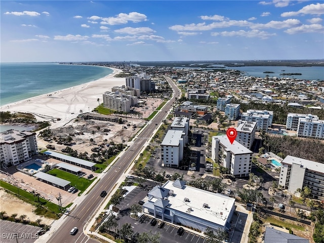 birds eye view of property featuring a water view, a view of the beach, and a city view