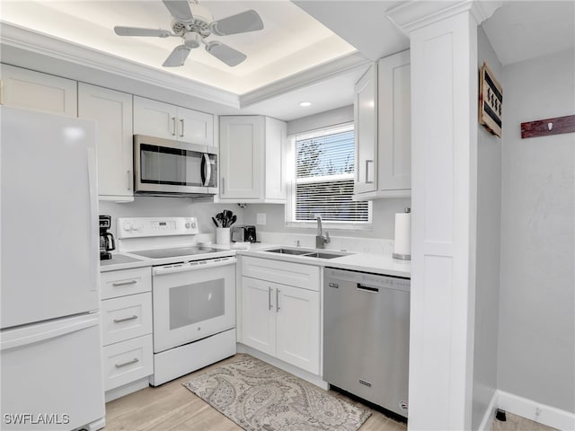 kitchen featuring white cabinets, a sink, light countertops, light wood-style flooring, and stainless steel appliances