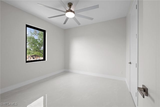 unfurnished room featuring baseboards, ceiling fan, and concrete floors
