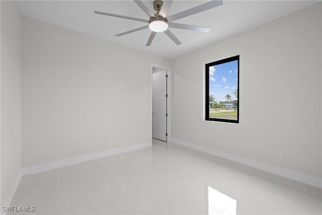 empty room with a ceiling fan and baseboards