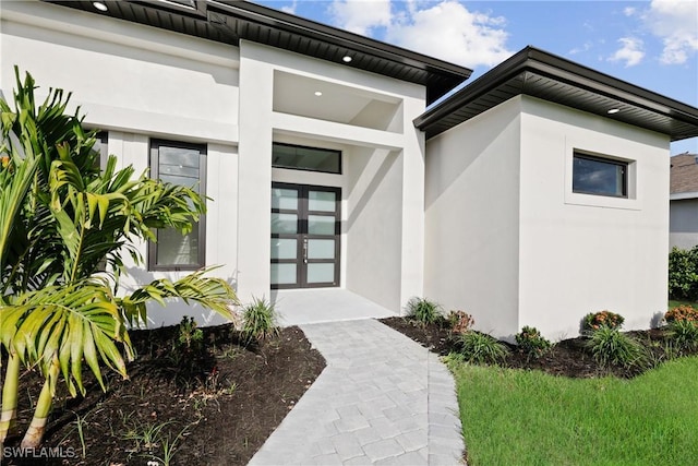 doorway to property featuring stucco siding and french doors