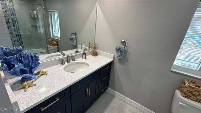 full bathroom with a healthy amount of sunlight, vanity, walk in shower, and toilet